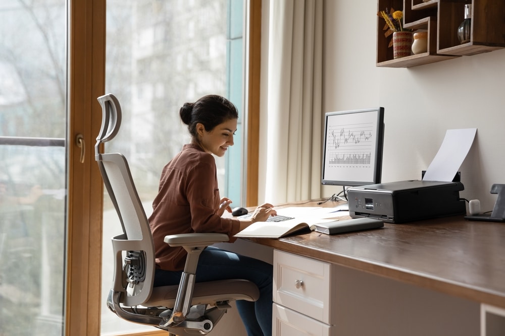 femme travaille sur fauteuil de bureau ergonomique